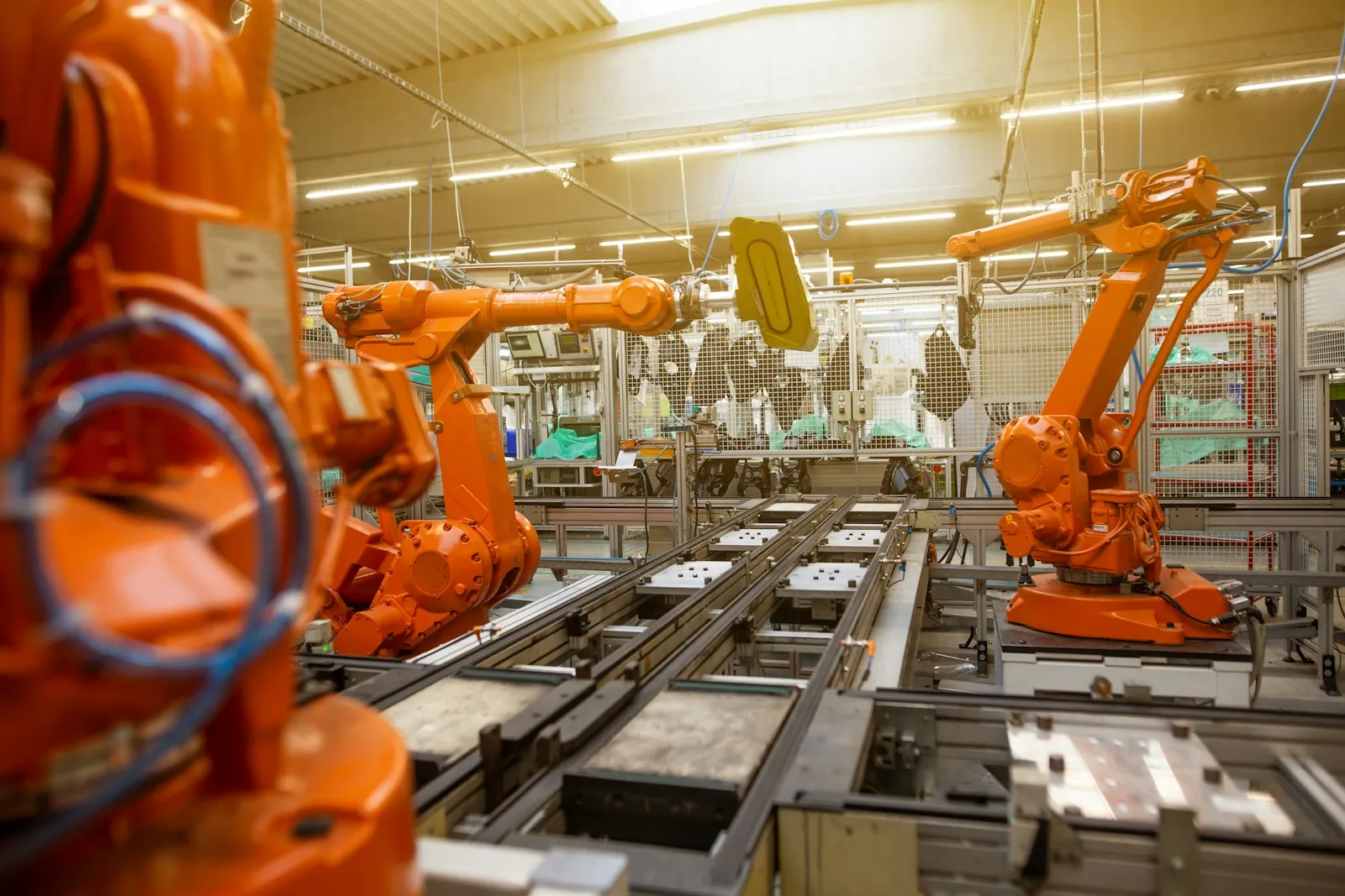 Orange robot arms at work on a production line